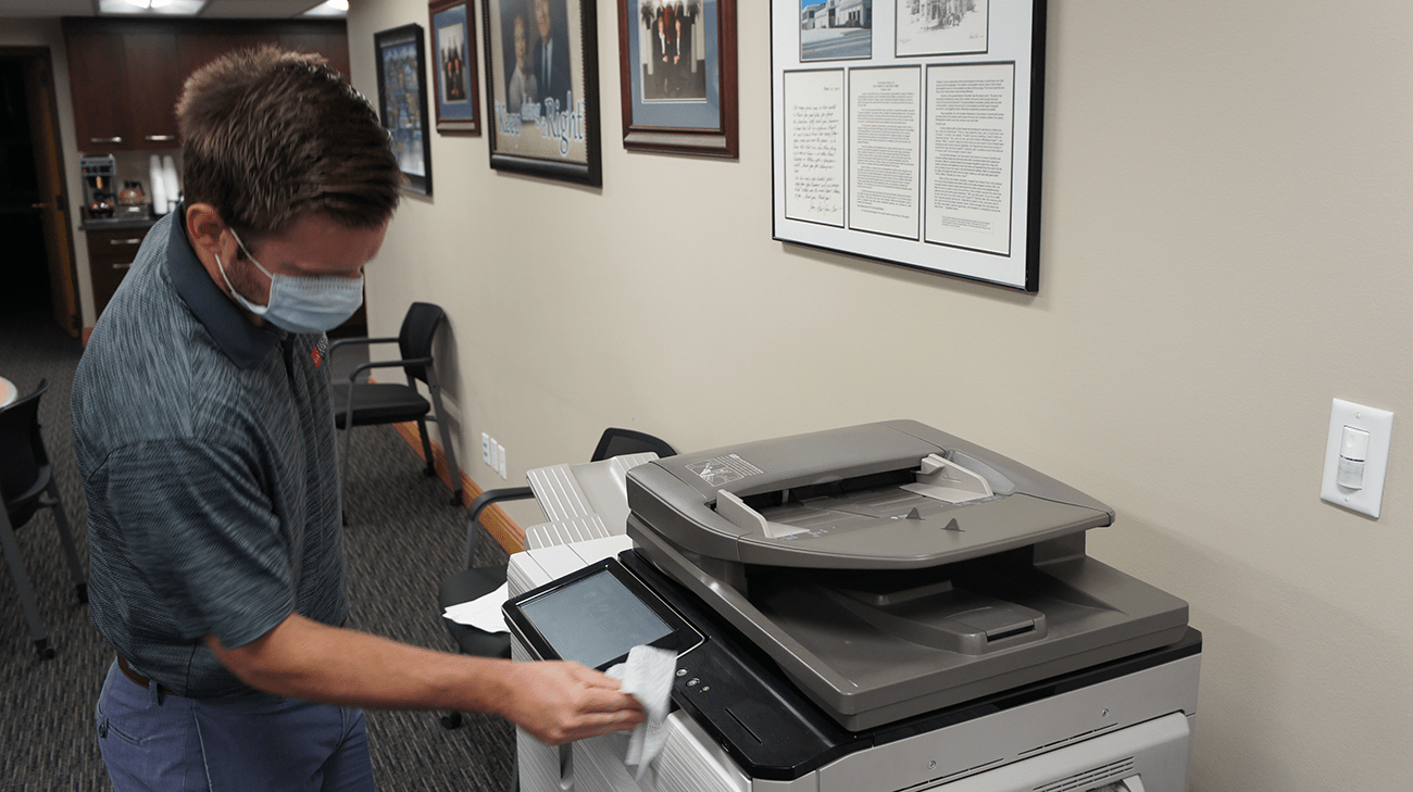 Stay Safe to Stay Open Utah Employee sanitizes copier