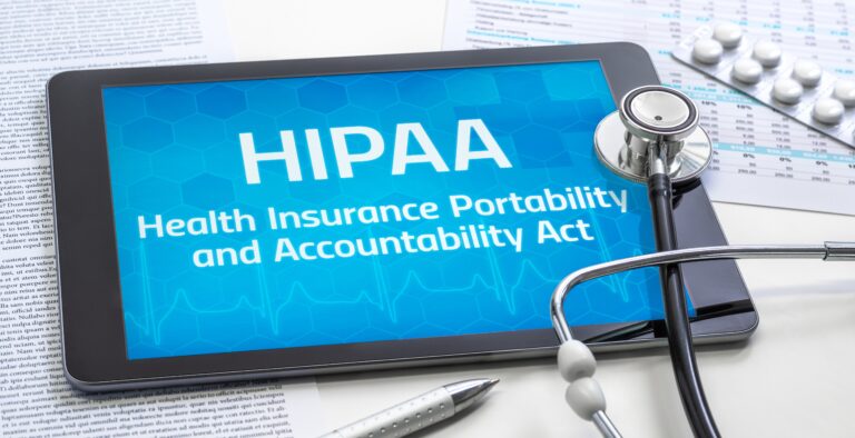 Tablet displaying HIPAA (Health Insurance Portability and Accountability Act) alongside a stethoscope, medical documents, and prescription pills, representing healthcare data privacy and compliance.