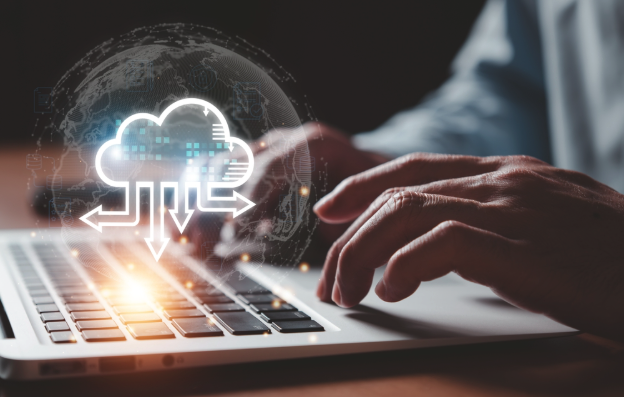 Cloud migration concept showing a user working on a laptop with a digital cloud computing icon, representing cloud storage, data transfer, and cloud services.