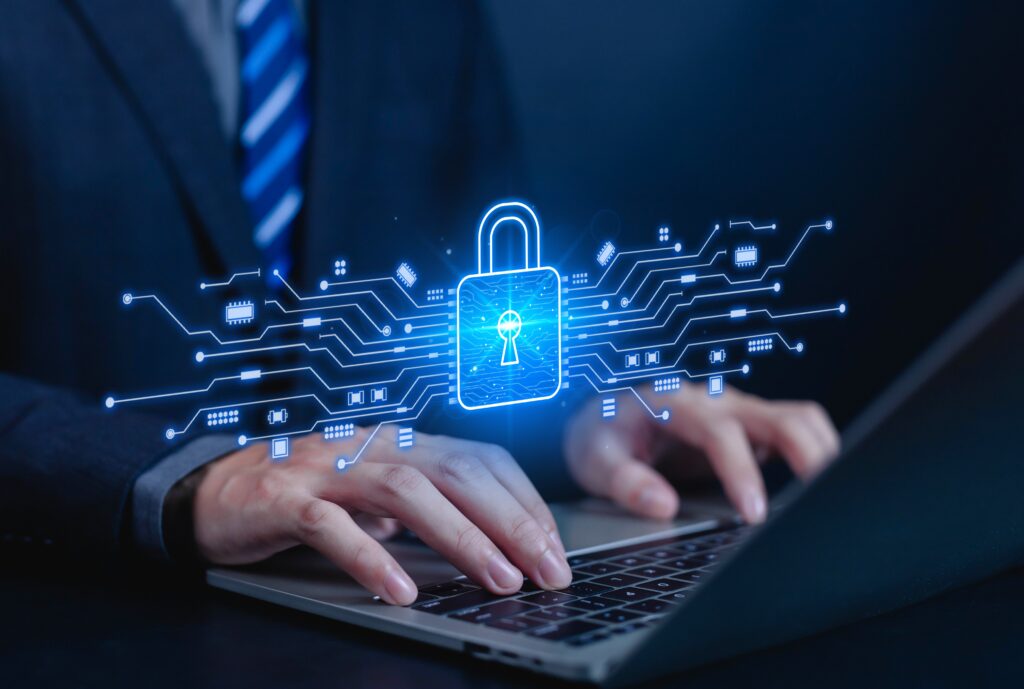 Business professional using a laptop with a digital padlock and network graphic representing cybersecurity and data protection.